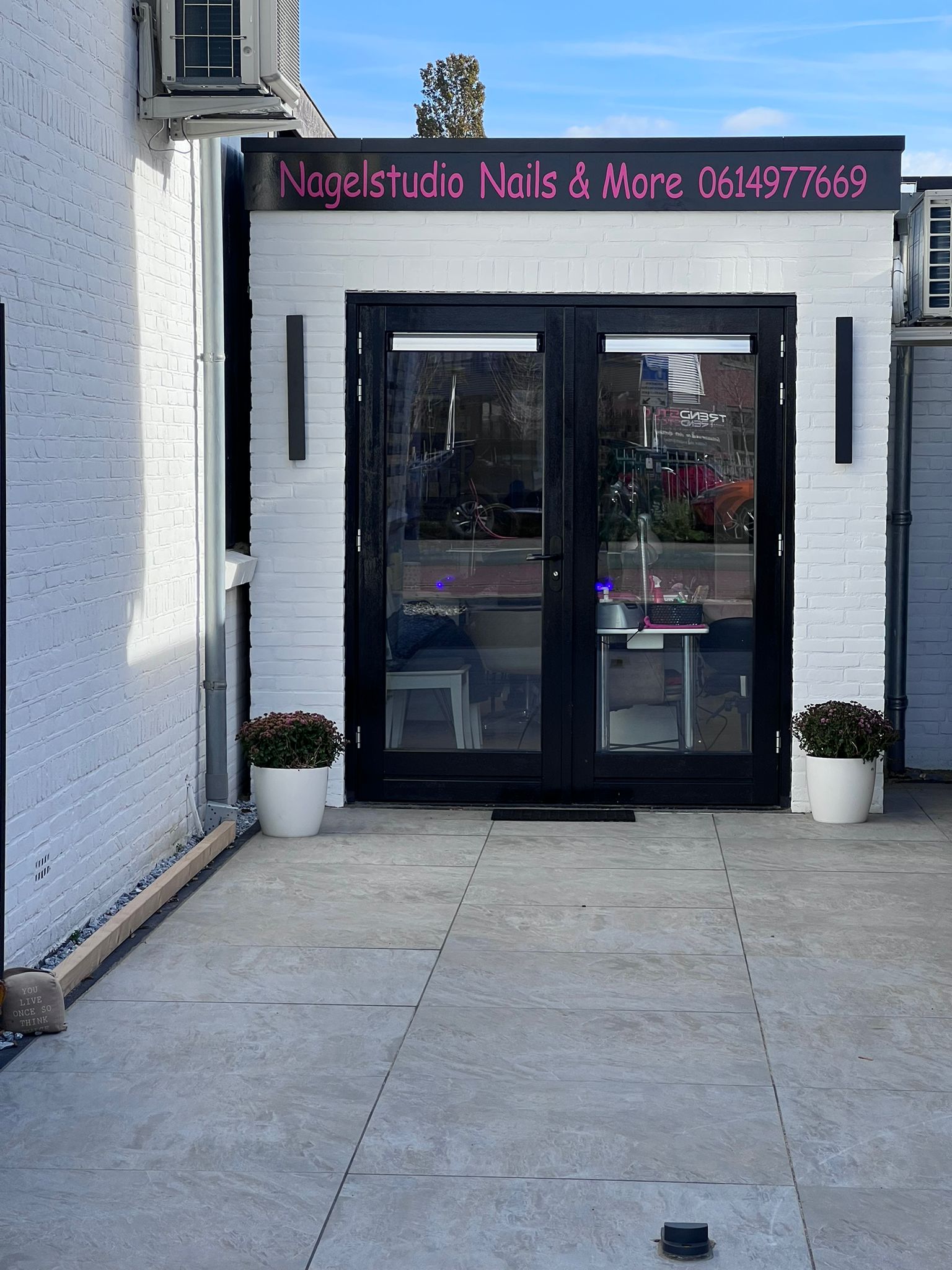 De zwarte deuren van de studio met het roze bord Nagelstudio Nails & More erboven